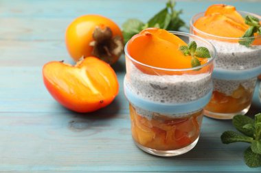 Hurmalı Chia tohumu pudingi ve açık mavi ahşap masada nane şekeri. Yakın plan.