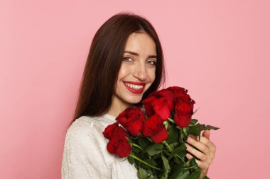 Sevgililer Günü. Pembe arka planda gülleri olan kadın