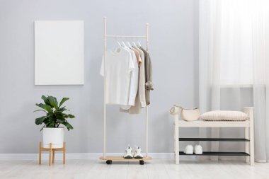 Farklı giysiler askıda, çantada ve ayakkabılarda asılı.