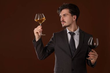 Kahverengi arka planda şarap kadehleri olan profesyonel şarap garsonu.