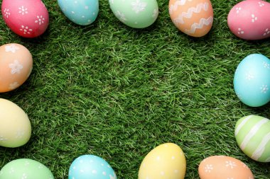 Yeşil çimlerin üzerinde güzel süslü Paskalya yumurtaları, düzlük. Metin için boşluk