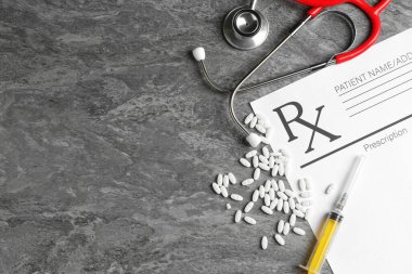 Boş tarlalar, steteskop, haplar ve gri desenli masa üzerine şırınga içeren tıbbi reçete formu. Metin için boşluk