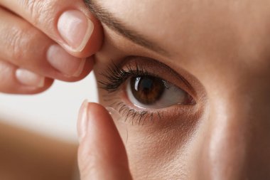 Kadın arka planda kontak lens takıyor, yakın plan