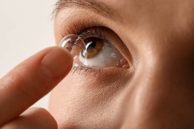 Kadın arka planda kontak lens takıyor, yakın plan