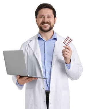 Paltolu gülümseyen eczacının portresi dizüstü bilgisayarı ve beyaz arka planda hapların su toplaması.