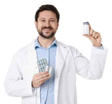 Tıbbi şişesi olan ve beyaz arka planda haplar olan gülümseyen eczacı.