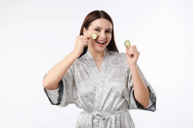 Beyaz arka planda salatalık dilimleri olan bir kadın.