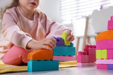 Küçük kız oyuncaklarla oynuyor oyun odasında, yakın plan.