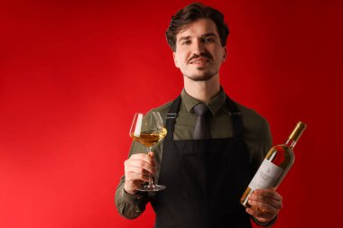 Kırmızı arka planda beyaz şarap ve şişe olan profesyonel şarap garsonu.