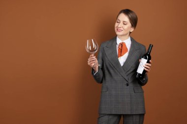 Kahverengi arka planda cam ve şarap şişesi olan profesyonel şarap garsonu. Metin için boşluk