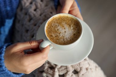 Evin içinde bir fincan aromatik kahvesi olan kadın, üst tarafta.