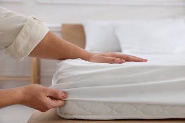 Adam yatak çarşaflarını kapalı bir yere koyuyor.