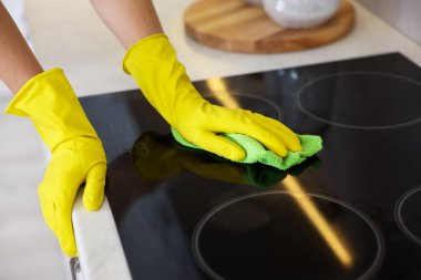 Mutfakta mikrofiber bezle fırın temizleyen kadın, yakın plan.