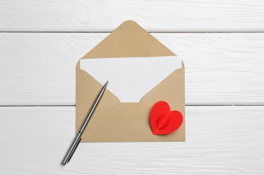 Zarfta aşk mektubu, kırmızı kalp ve beyaz ahşap masa, üst görünüm