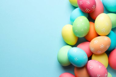 Açık mavi arka planda birçok Paskalya yumurtası boyanmış. Metin için boşluk