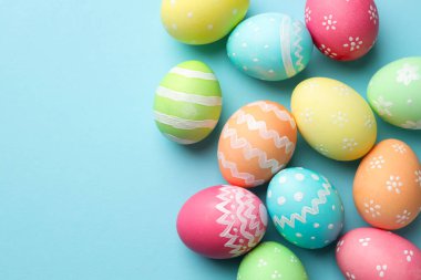 Açık mavi arka planda birçok Paskalya yumurtası boyanmış. Metin için boşluk