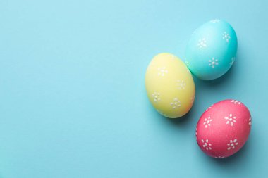 Açık mavi arka planda birçok Paskalya yumurtası boyanmış. Metin için boşluk