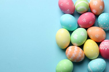 Açık mavi arka planda birçok Paskalya yumurtası boyanmış. Metin için boşluk