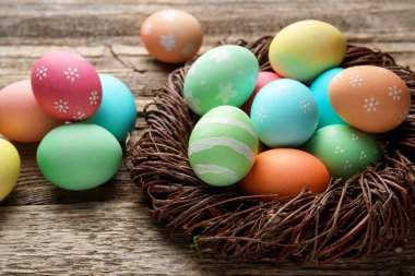 Güzel dekore edilmiş Paskalya yumurtaları ahşap masada, yakın plan.