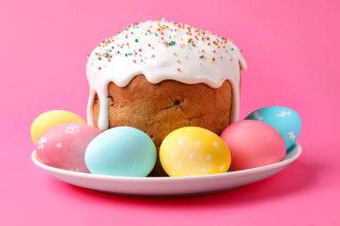 Enfes Paskalya pastası ve pembe arka planda süslü yumurtalar, yakın plan.