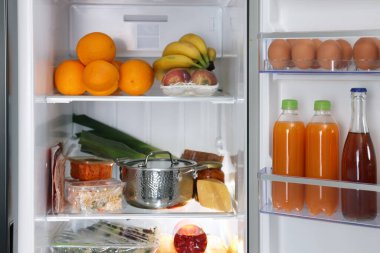 Farklı taze gıda ürünleri olan modern buzdolabı, yakın plan.