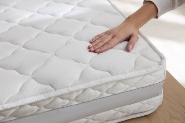 Yatakta yumuşak yatağa dokunan kadın, yakın plan.