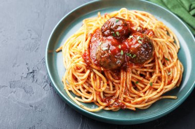 Köfteli lezzetli makarna, siyah desenli masa, yakın plan.