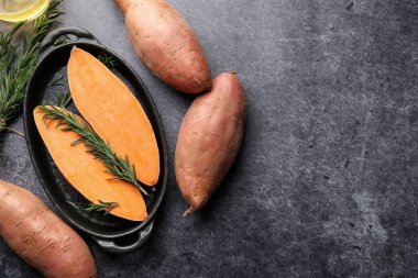 Çiğ patates, biberiye ve yağ siyah masada, düz yerde. Metin için boşluk