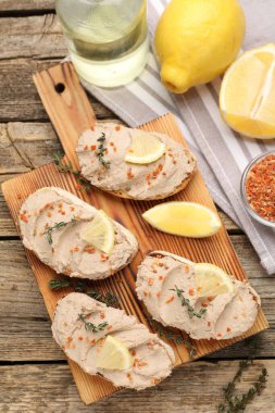 Lezzetli bruschettalar, ezme, limon dilimleri, kekik ve kurutulmuş havuç taneleri ahşap masa, düz uzanmış