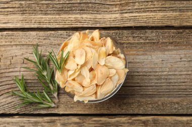 Kasede kurutulmuş sarımsak gevreği ve ahşap masada biberiye. Metin için boşluk