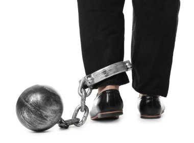 Bacağında beyaz arka planda metal top ve zincir olan bir iş adamı, yakın plan.
