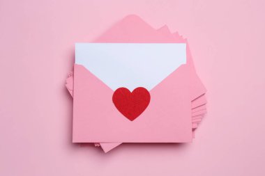 Pembe arka planda aşk mektupları yığını, üst görünüm