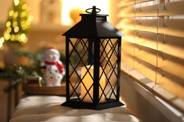 Güzel Noel feneri ve evdeki pencerenin yanındaki bankta bulunan diğer şenlikli dekorlar.