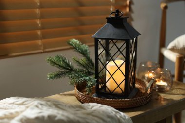 Noel feneri, yanan mumlar ve kapalı bir bankta köknar dalları, yakın çekim. Sıcak atmosfer