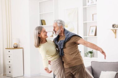 Güzel yaşlı çift evde dans ediyor.