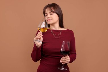 Soluk kahverengi arka planda şarap kadehleri olan profesyonel şarap garsonu.