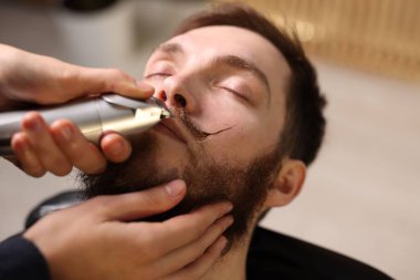 Berber dükkanında adamın bıyığını buduyor, yakın plan