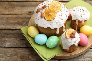 Nefis dekore edilmiş Paskalya pastaları ve yumurtalar ahşap masada, yakın plan.