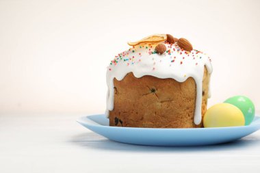 Lezzetli dekore edilmiş Paskalya pastası ve beyaz ahşap masada yumurtalar. Metin için boşluk