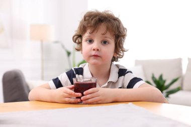 İçerideki masada taze nar suyu olan küçük bir çocuk.