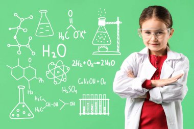 Açık yeşil arka planda koruyucu gözlükleri ve kimyayla ilgili çizimleri olan sevimli küçük bir kız. Fen okuyorum.