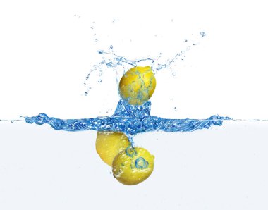 Taze olgun limonlar beyaz arka planda suya düşüyorlar.