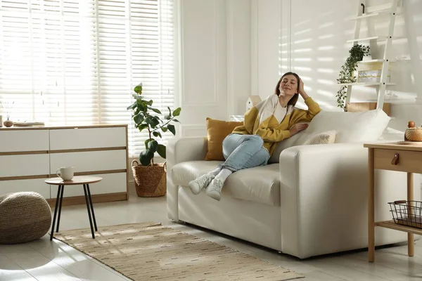 Mutlu kadın evdeki kanepede dinleniyor.