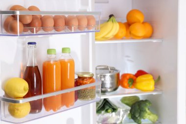 Farklı taze gıda ürünleri olan modern buzdolabı, yakın plan.