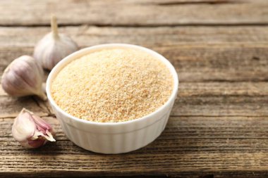 Kasede kurutulmuş sarımsak ve ahşap masada taze sebzeler, yakın plan. Metin için boşluk