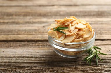 Kasede kurutulmuş sarımsak gevreği ve ahşap masada biberiye, yakın plan. Metin için boşluk