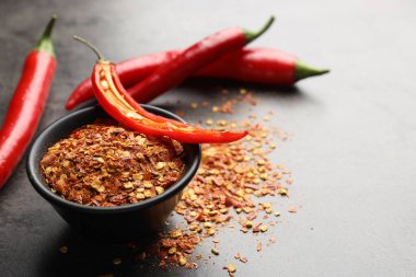 Kırmızı biberler ve gevrekler gri masada, yakın plan. Metin için boşluk