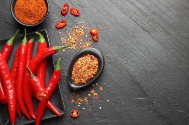 Kırmızı biber, pul biber ve kırmızı biber tozu gri desenli masada, düz yerde. Metin için boşluk