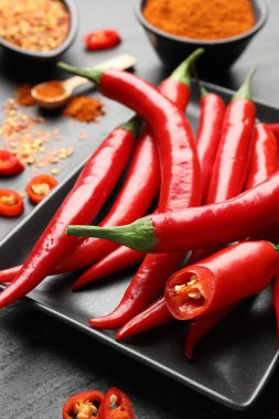 Kırmızı biber, gevrek ve kırmızı biber tozu gri desenli masada, yakın plan.