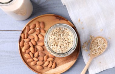 Yulaf gevreği, fındık ve badem sütü gri ahşap masa üzerinde, düz yatıyordu.